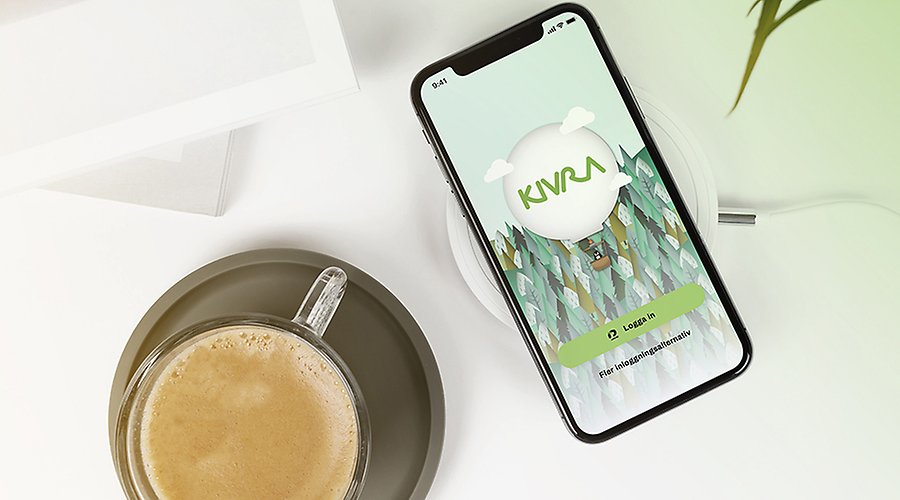 Telefon på bord bredvid kaffekopp, Kivras app